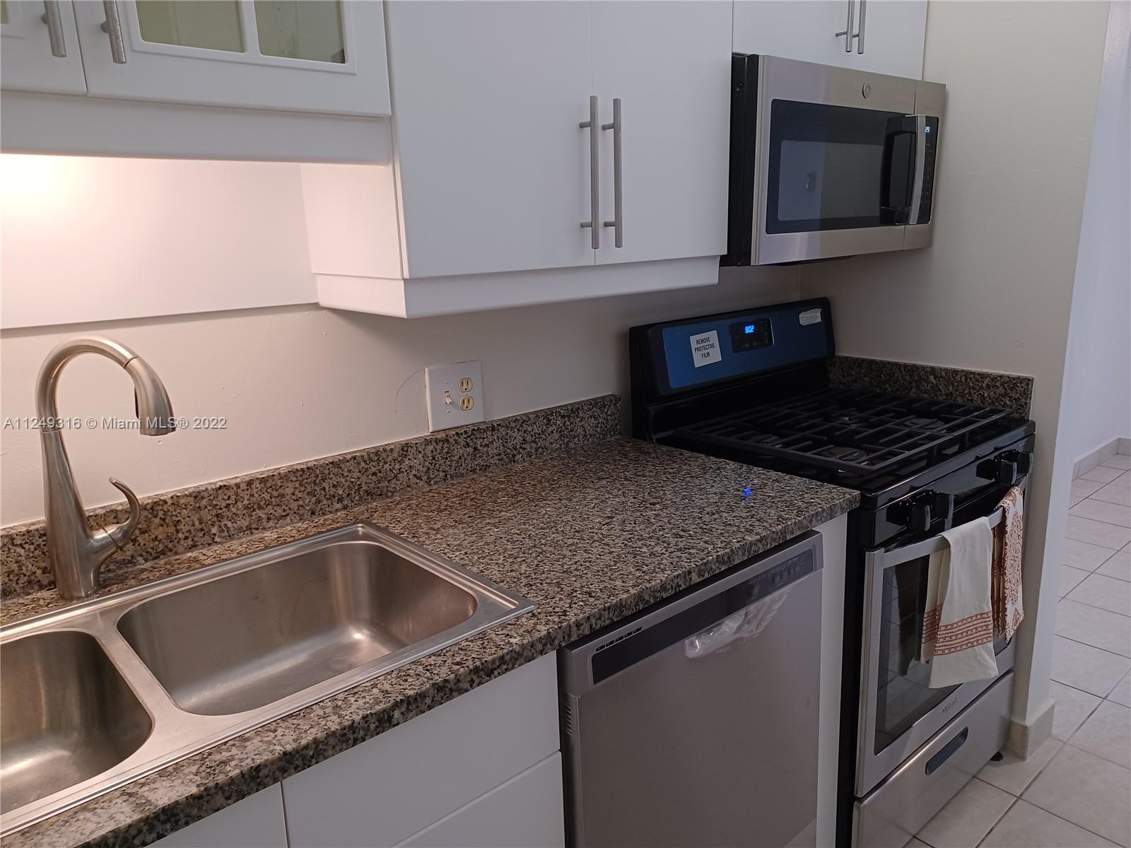 Andover Lakes Miami Gardens, FL 33179 - Photo 39 of 41 a kitchen with granite countertop a sink and a stove