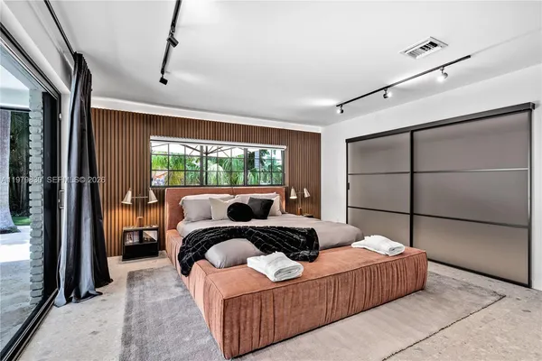 a bedroom with a large bed and a chandelier