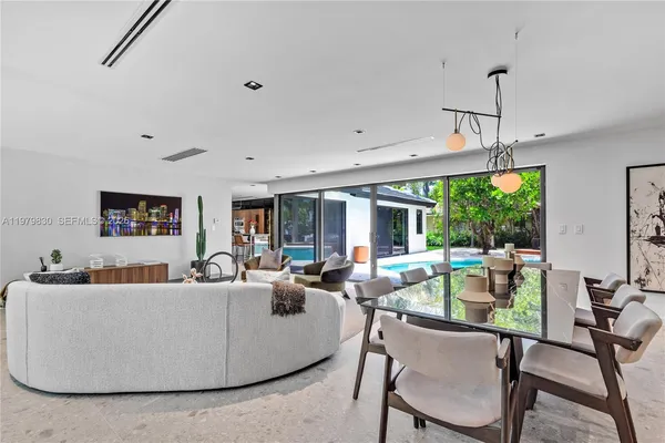a living room with furniture a ceiling fan and a large window