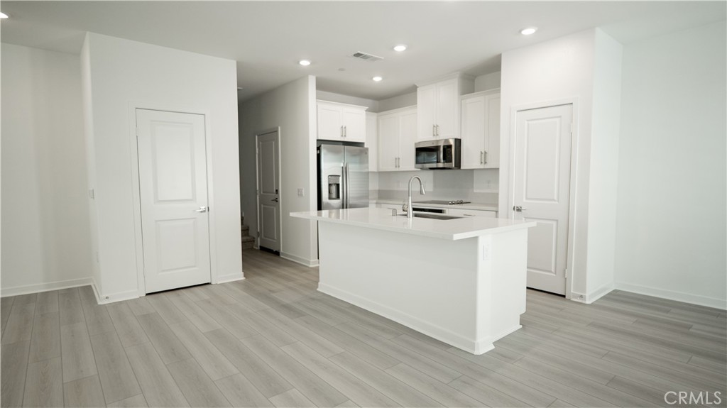 8457 Gabrielino Court Rancho Cucamonga, CA 91730 - Photo 58 of 58 a kitchen with white cabinets and stainless steel appliances