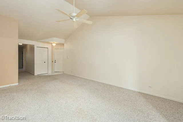 an empty room with a ceiling fan and a bathroom