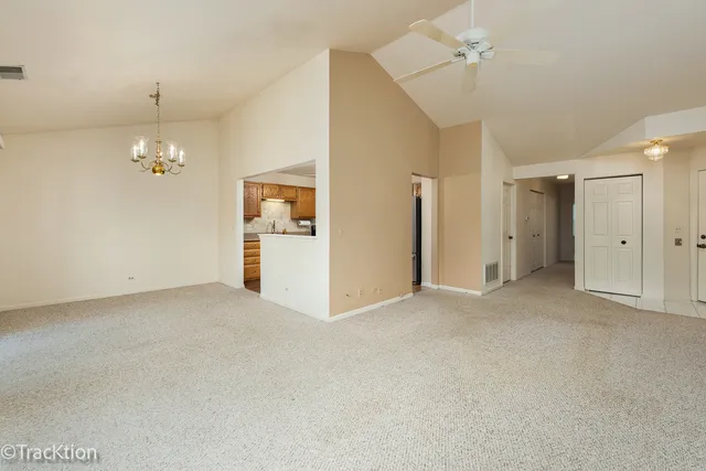 a view of a big room with chandelier fan and windows