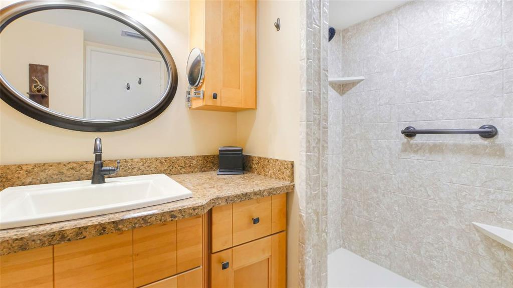 7150 Sunset Way, Unit 903E St. Pete Beach, FL 33706 - Photo 11 of 26 a bathroom with a granite countertop sink and a mirror