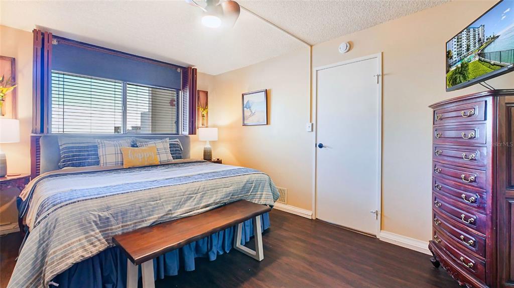 7150 Sunset Way, Unit 903E St. Pete Beach, FL 33706 - Photo 12 of 26 a bedroom with a bed and a dresser in it