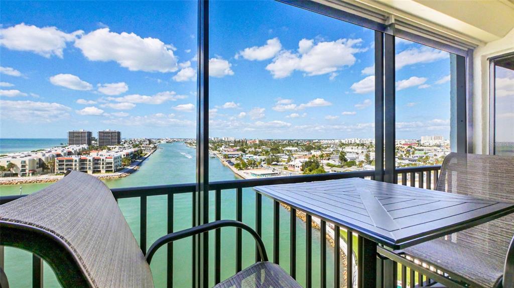 7150 Sunset Way, Unit 903E St. Pete Beach, FL 33706 - Photo 3 of 26 a view of a balcony dining table and chairs