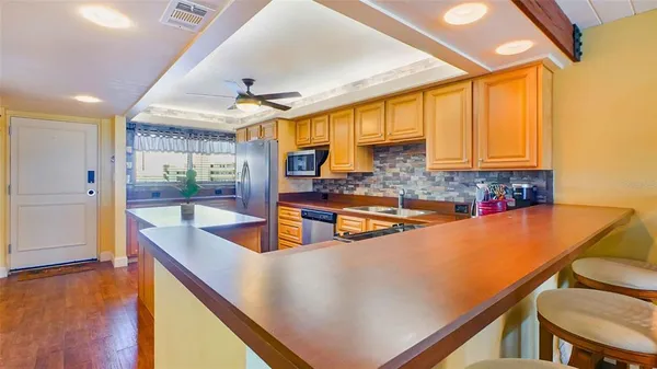 a kitchen with stainless steel appliances granite countertop a sink a stove and a refrigerator