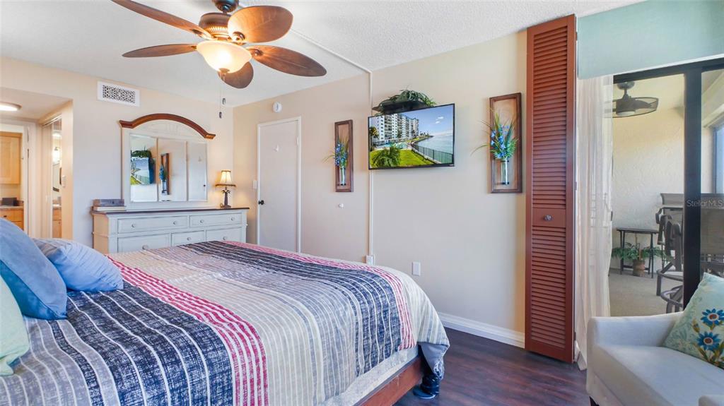 7150 Sunset Way, Unit 903E St. Pete Beach, FL 33706 - Photo 10 of 26 a bedroom with a bed and a chandelier