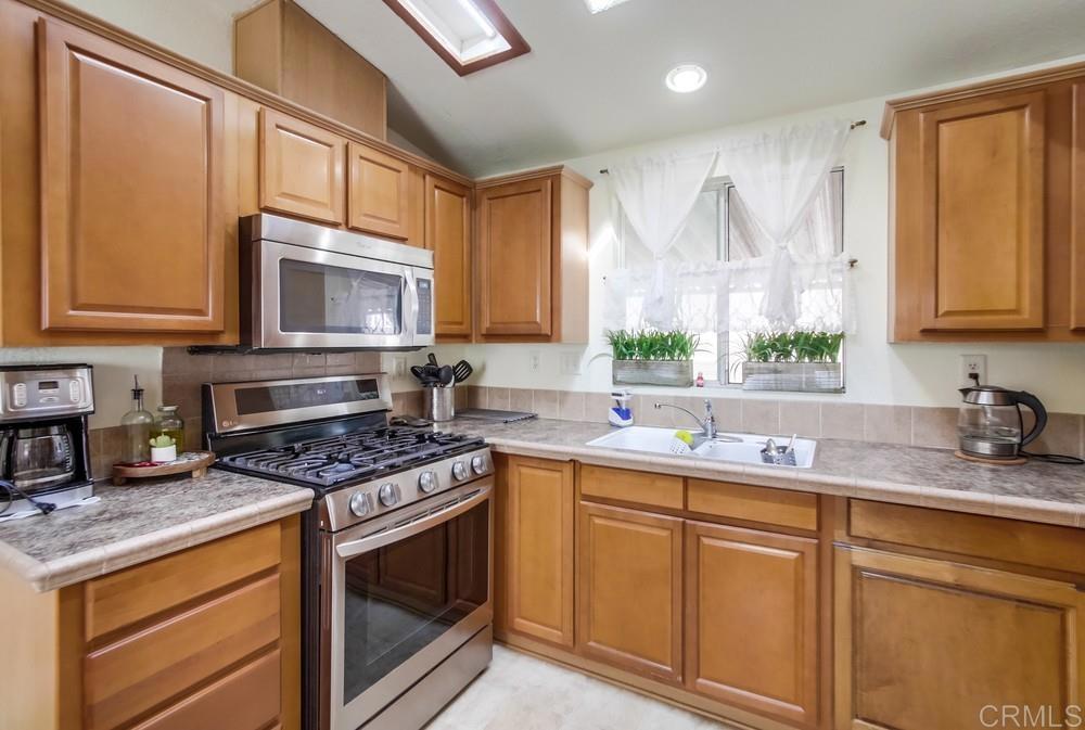 9902 Jamacha Boulevard, Unit SPC 7 Spring Valley, CA 91977 - Photo 16 of 33 a kitchen with stainless steel appliances granite countertop a sink stove microwave and cabinets