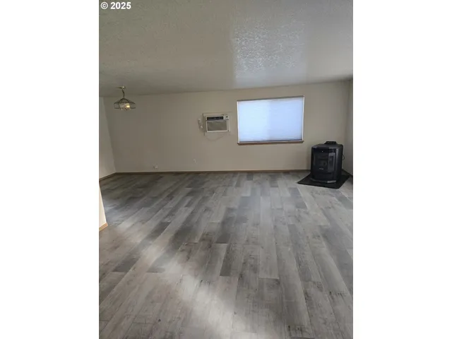 a view of a room with wooden floor and a window