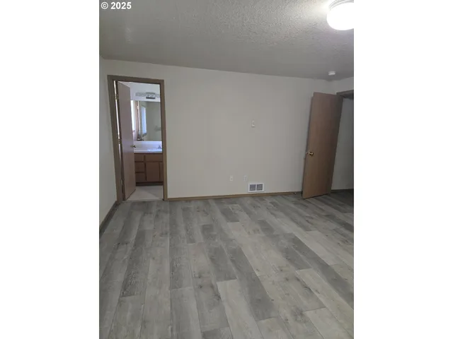 a view of a room with wooden floor and a window