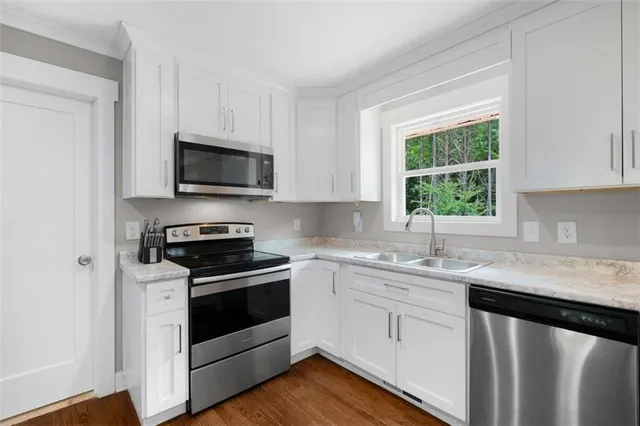 a kitchen with a sink stove top oven and cabinets