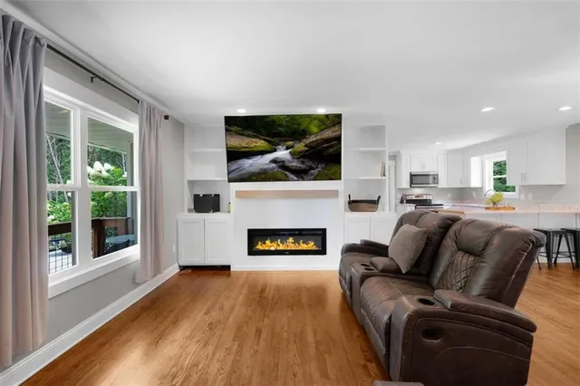 a living room with furniture a fireplace and a flat screen tv
