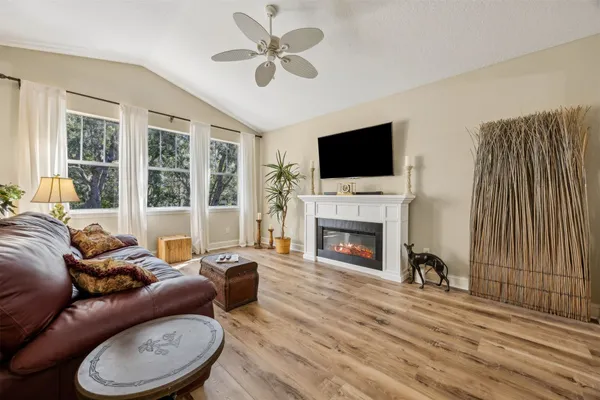 a living room with furniture a fireplace and a flat screen tv