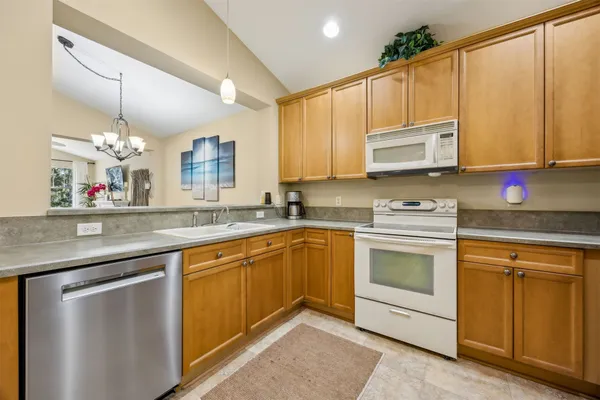 a kitchen with stainless steel appliances granite countertop a sink a stove a microwave a counter space and cabinets