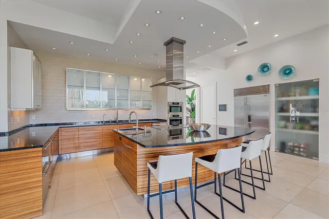 a large kitchen with stainless steel appliances granite countertop a sink and cabinets