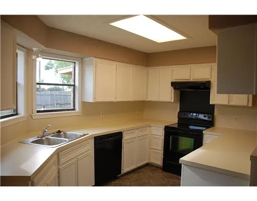 a kitchen with a sink cabinets and a window