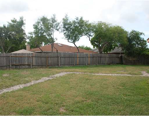 7202 Sandpiper Drive Corpus Christi, TX 78412 - Photo 9 of 10 a view of a backyard with large trees and wooden fence