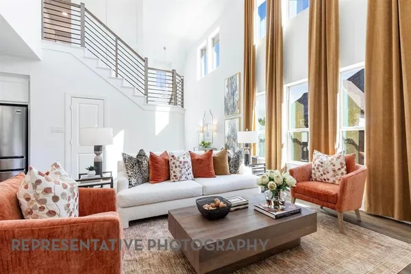 a living room with furniture kitchen view and a large window