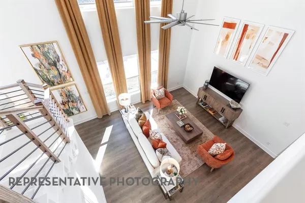 a living room with furniture kitchen view and a wooden floor