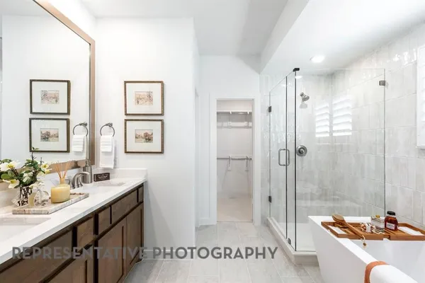 a bathroom with a tub a mirror and a shower