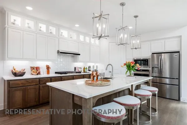 a kitchen with stainless steel appliances granite countertop a sink and a refrigerator