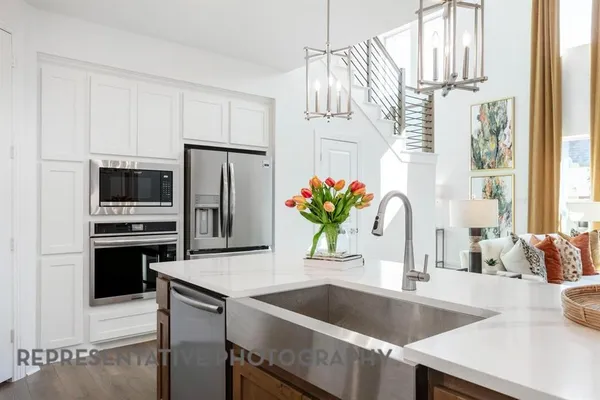 a kitchen with granite countertop a table chairs stove and cabinets