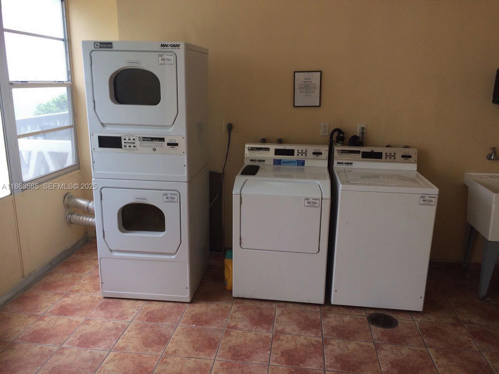 1430 Brickell Bay Drive, Unit 301 Miami, FL 33131 - Photo 15 of 18 a utility room with dryer and washer