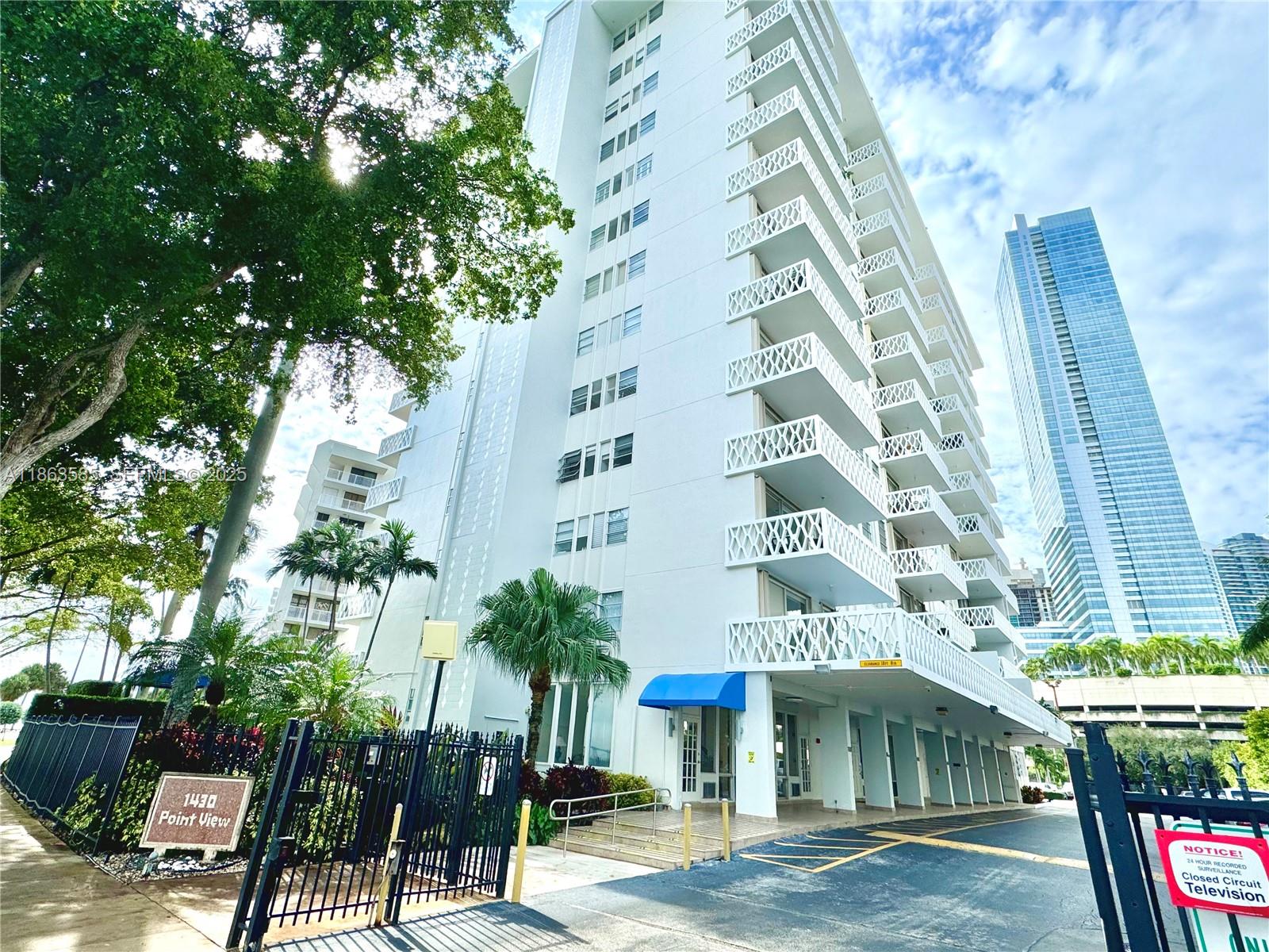 1430 Brickell Bay Drive, Unit 301 Miami, FL 33131 - Photo 2 of 18 a front view of a multi story building with yard