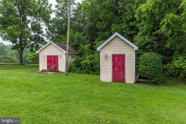 a view of a house with a yard and large trees
