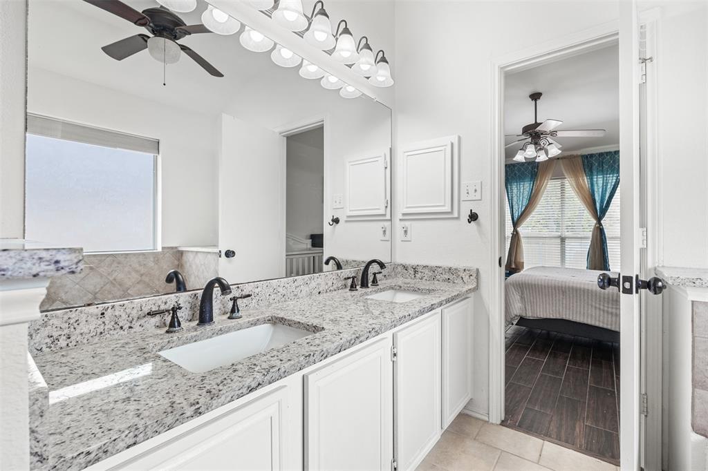 1011 Ridgecrest Drive McKinney, TX 75069 - Photo 21 of 31 Bathroom featuring a dual vanity with light-toned granite countertops, undermount sinks, and matte black fixtures