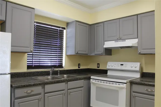 a kitchen with granite countertop a sink cabinets and stainless steel appliances