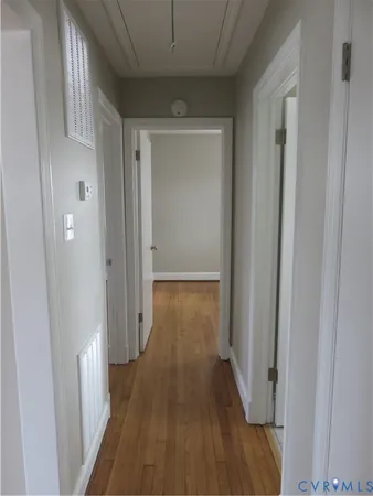 a view of a hallway with wooden floor
