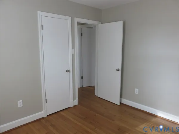 a view of an empty room with wooden floor