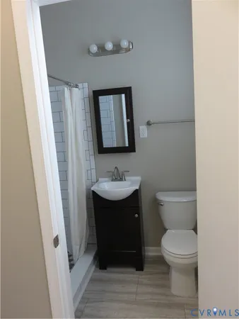 a bathroom with a toilet a sink and mirror