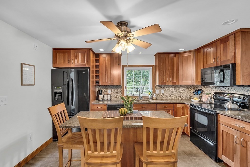 180 County Road Tewksbury, MA 01876 - Photo 12 of 40 a kitchen with stainless steel appliances granite countertop a sink a stove a refrigerator cabinets and dining table