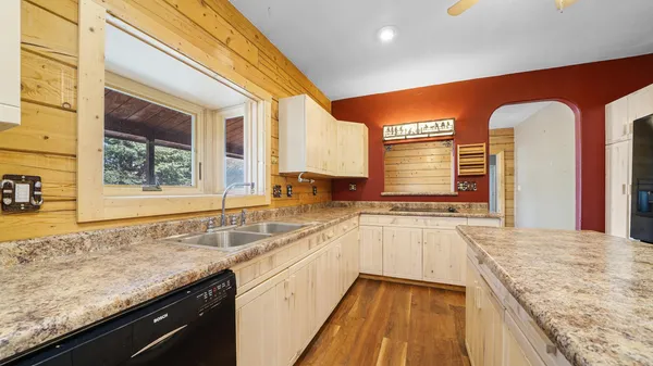 a kitchen with stainless steel appliances granite countertop a sink a stove and a refrigerator