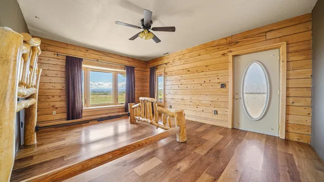 a view of a hallway with wooden floor and stairs