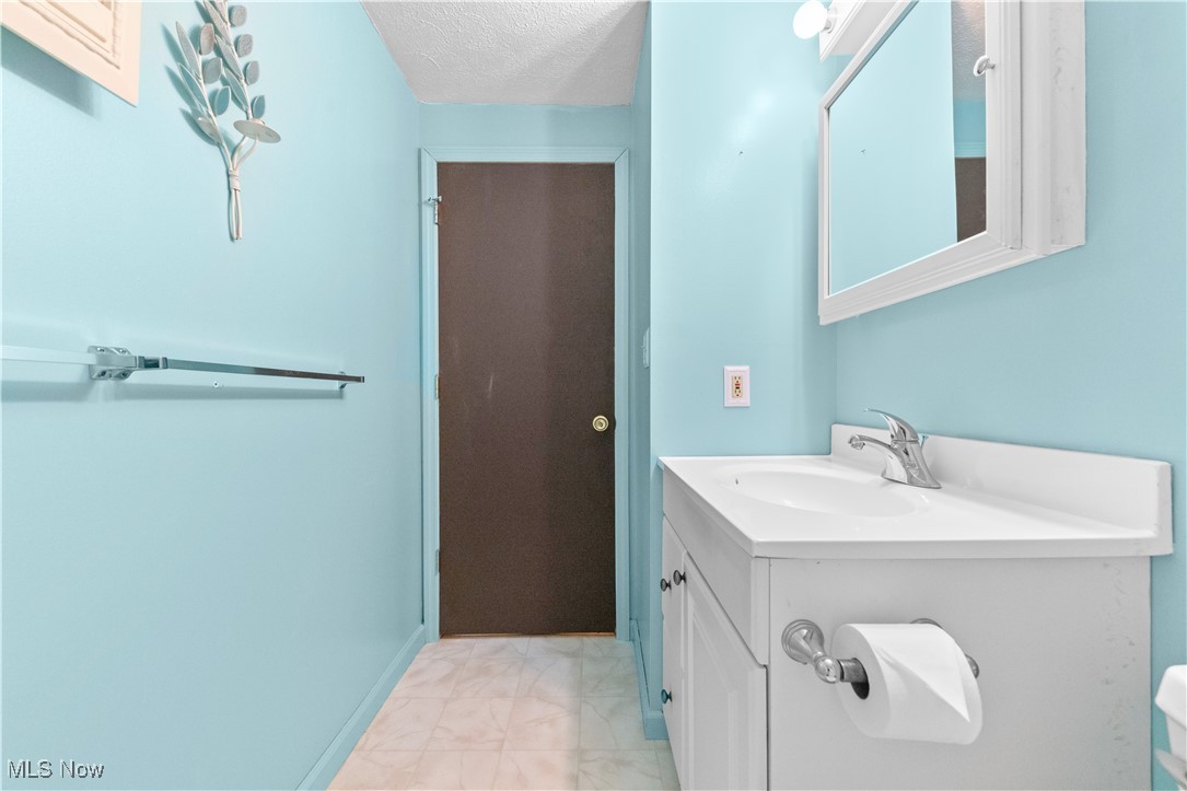 4301 Baird Road Stow, OH 44224 - Photo 18 of 50 Bathroom featuring marble finish floor, vanity, and a textured ceiling
