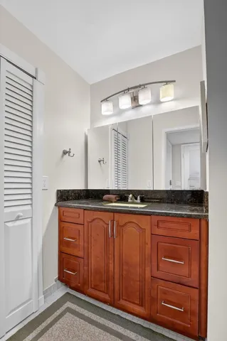 a bathroom with a sink a toilet a mirror and shower