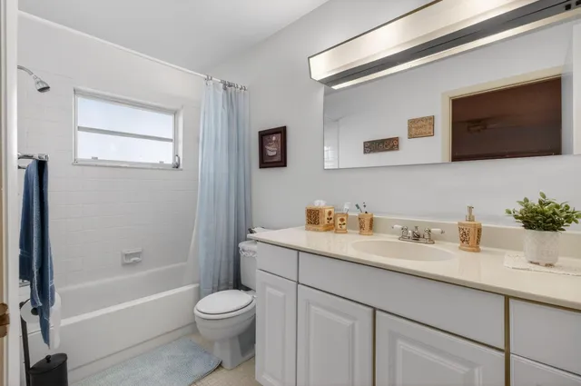 a bathroom with a granite countertop sink toilet a large mirror a shower and bathtub