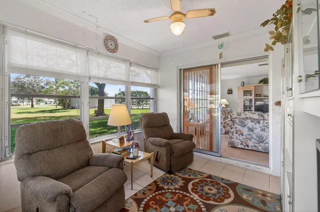 a living room with furniture and a floor to ceiling window