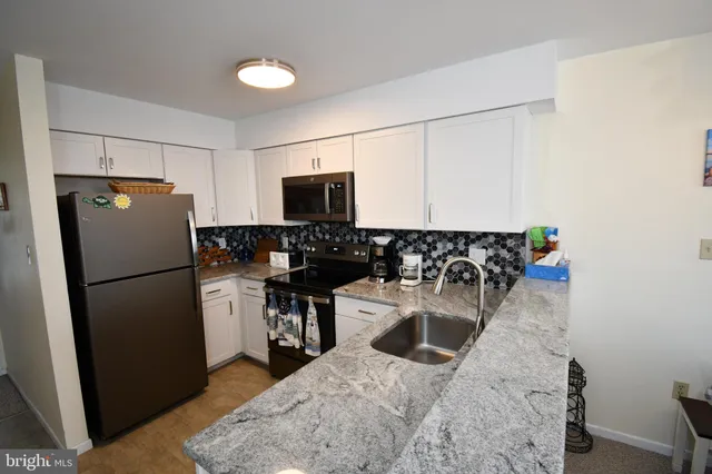 a kitchen with a refrigerator a stove and a sink