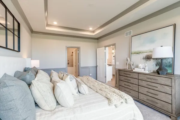 a spacious bedroom with a bed and a dresser