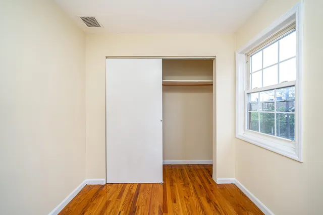 a view of an empty room with wooden floor