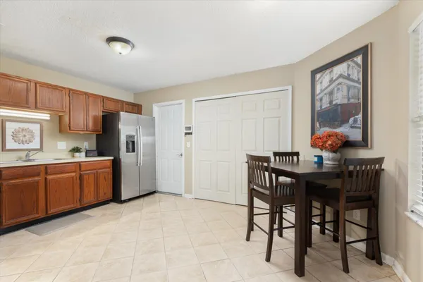 a kitchen with stainless steel appliances granite countertop a table chairs and a refrigerator
