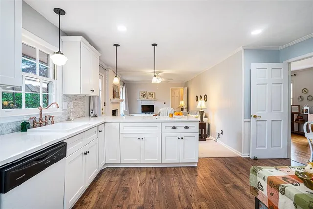 a large kitchen with a lot of counter space and wooden floor