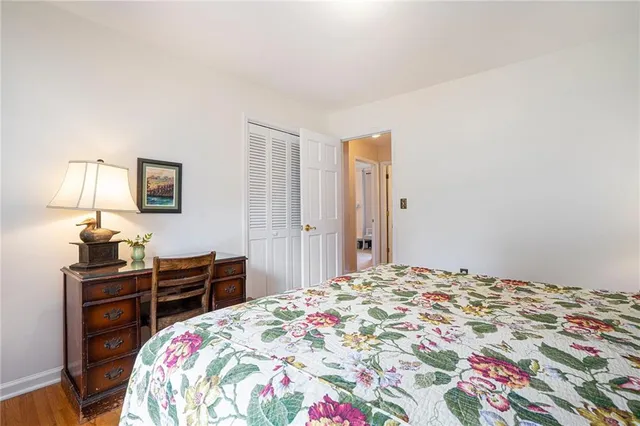 a bedroom with a bed and dresser with mirror