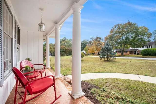 a view of a porch with furniture and a yard
