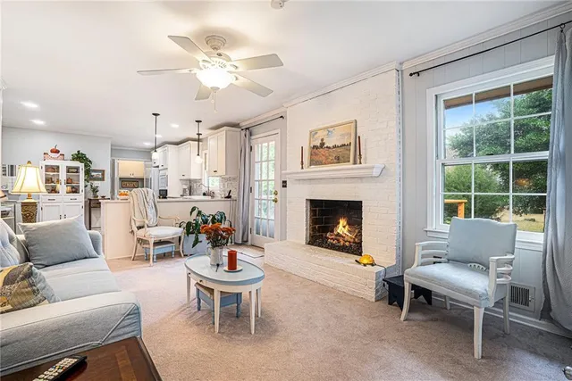 a living room with furniture a fireplace and a large window