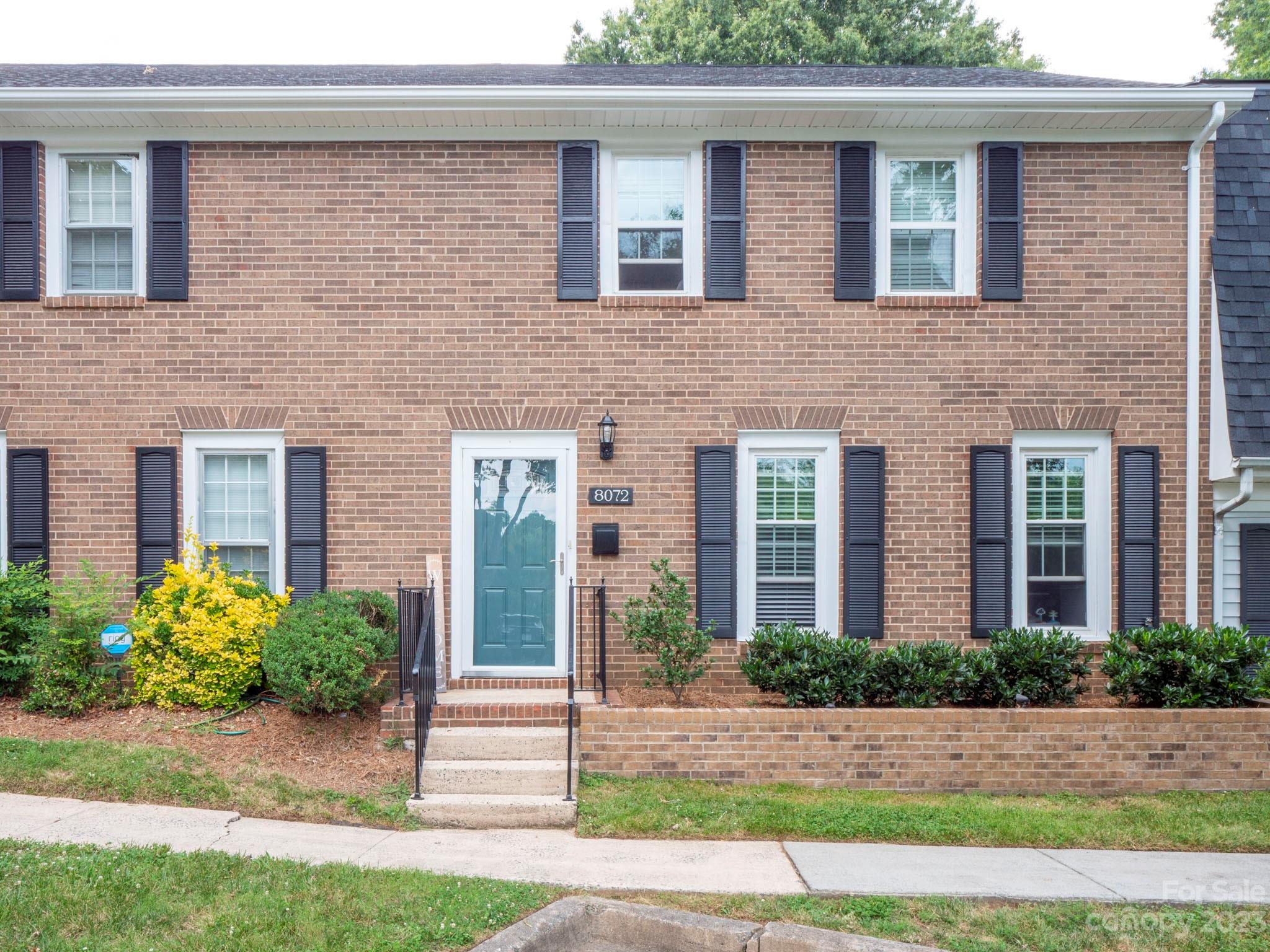 front view of a brick house with a small yard